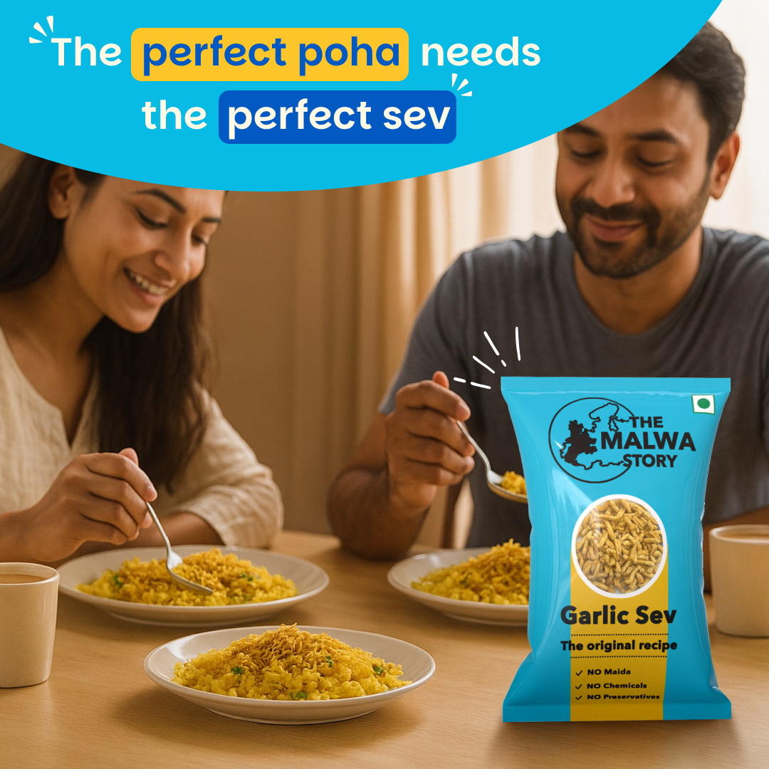 Two people enjoying a meal with plates of food and a packet of 'The Malwa Story' Garlic Sev on a table.